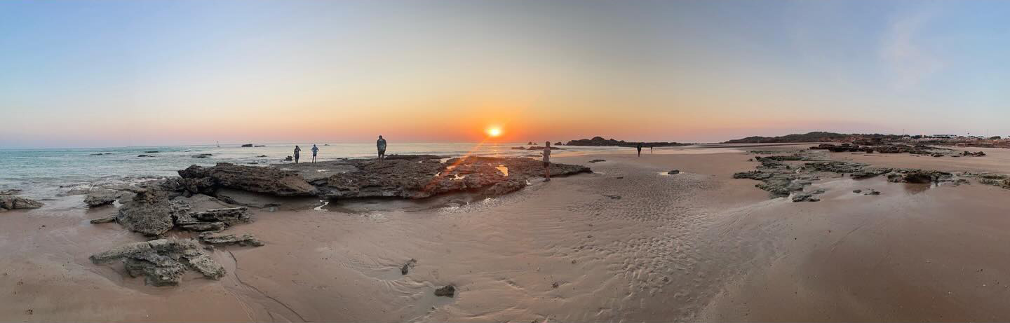 Panorama image of Broome Residential College boarders on the beach at sunset