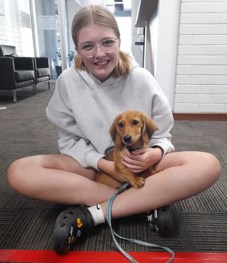 Northam Residential College boarder holding Hank the sausage dog