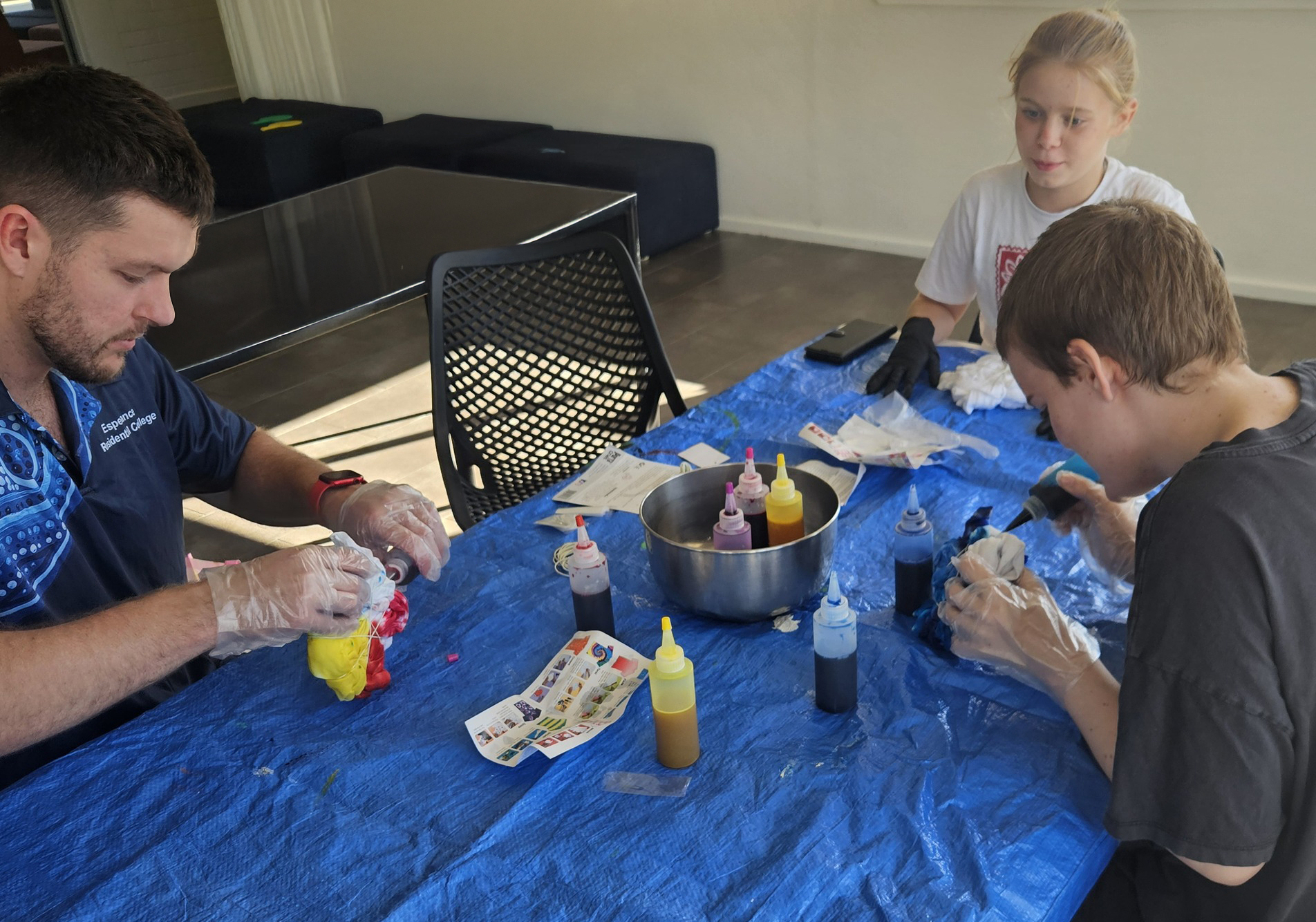 Esperance Residential College boarding supervisor guiding students in a tie-dying activity.