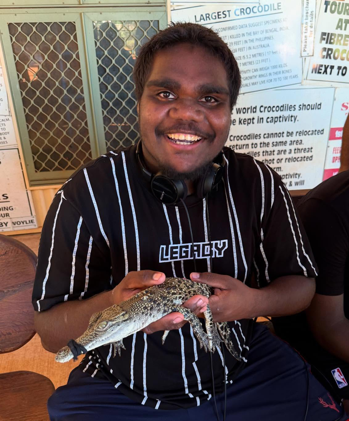 Broome Residential College boarder holding a baby crocodile at the crocodile park