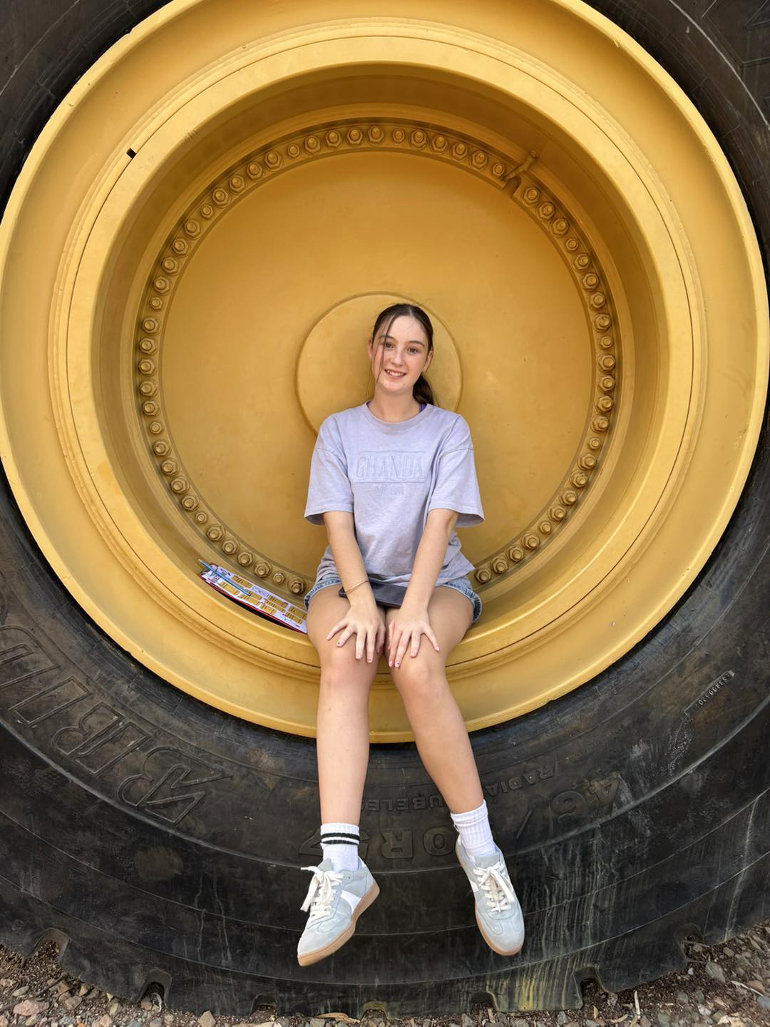Merredin Residential College boarder sitting on a hug tyre on Kalgoorli excursion