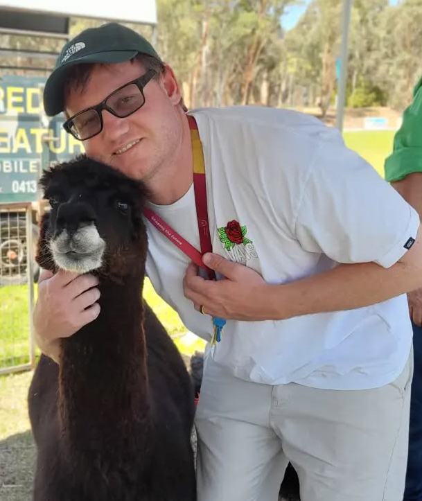 Boarding Supervisor from Northam Residential College smiling next to an alpaca.