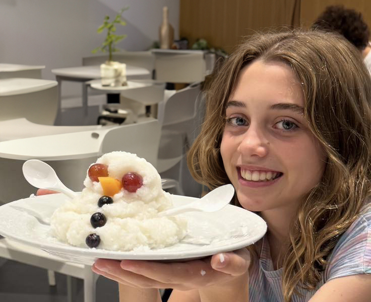 City Beach Residential College boarder holding up a plate of food in the shape of a melted snowman