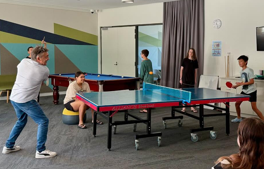 Boarding supervisor playing table tennis with boarders from City Beach Residential College