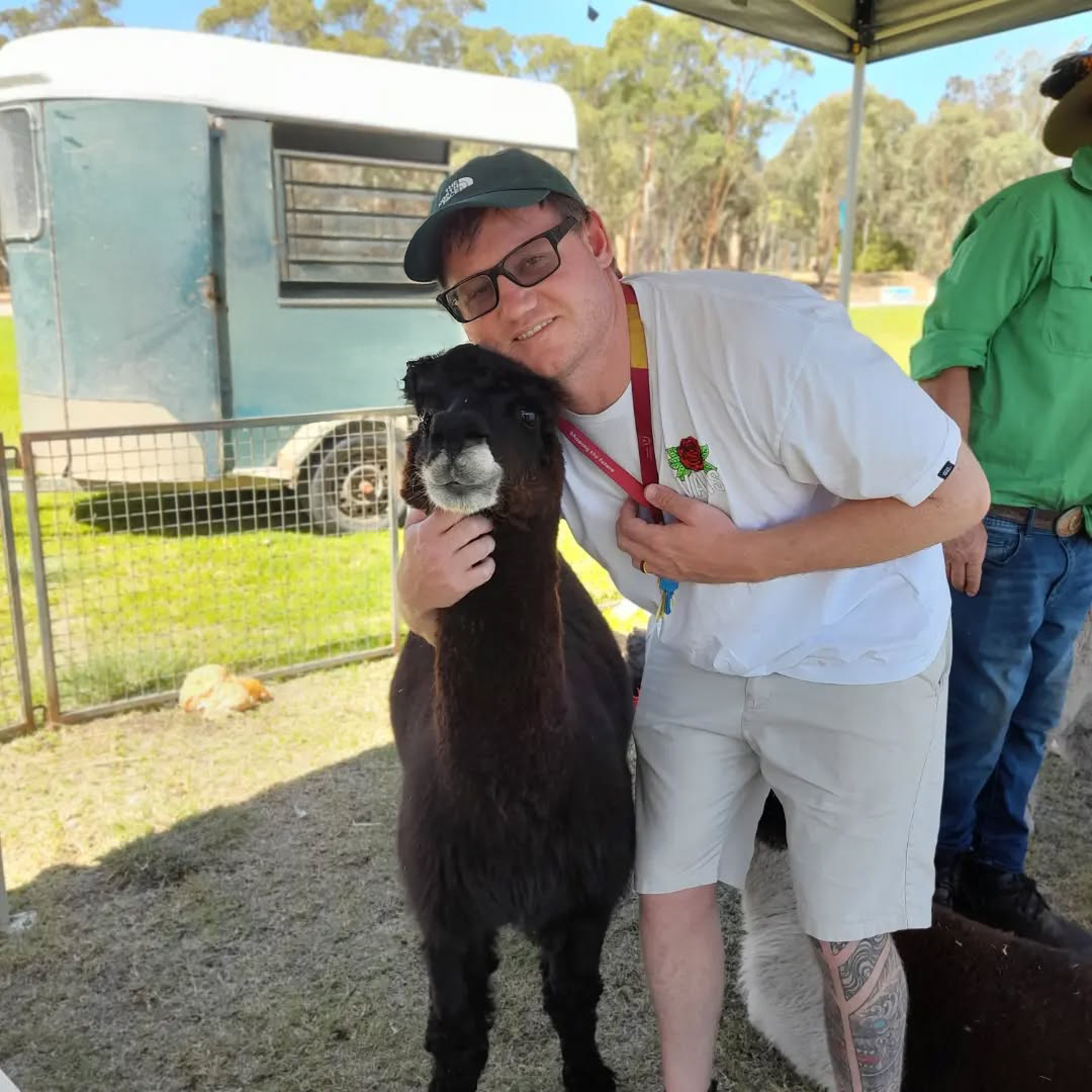 Northam Residential College boarding supervisor cuddling up with an alpaca at the local markets