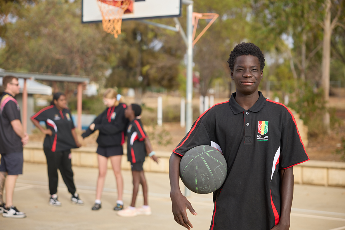 Northam Residential College boarder holding a basketball on the college courts.
