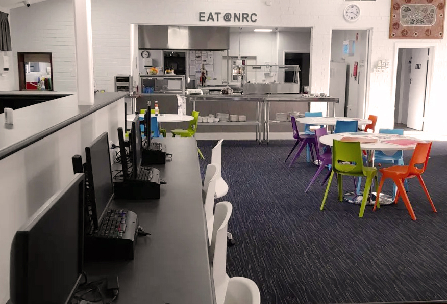 Common room with computers and dining table at Northam Residential College