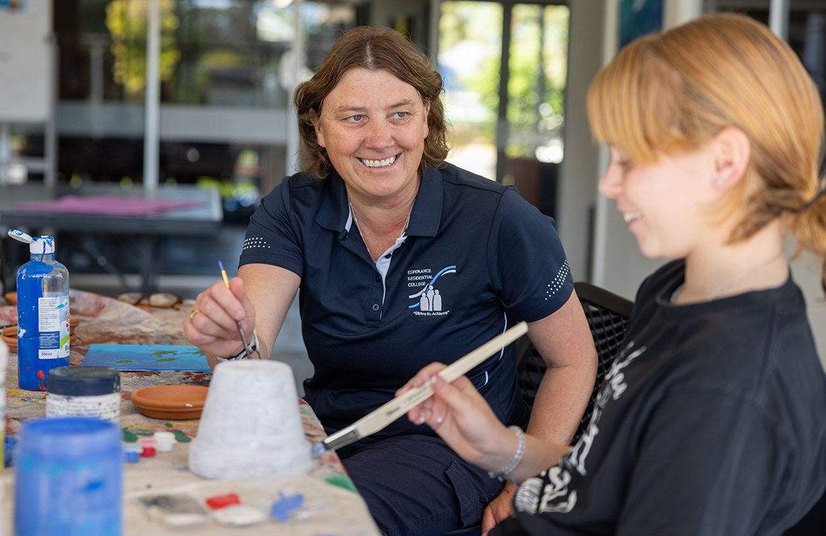 Boarding supervisor from Esperance Residential College helping a student with homework.
