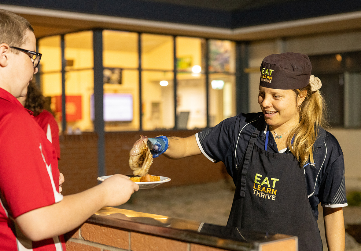 A smiling boarding supervisor from Esperance Residential College serving up a delicious bbq.