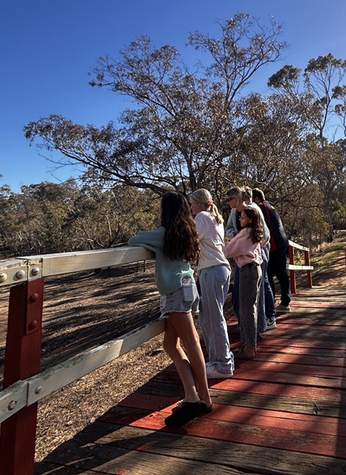 Boarders from Narrogin Residential College on a weekend walk and looking out over a wooden footbridge.