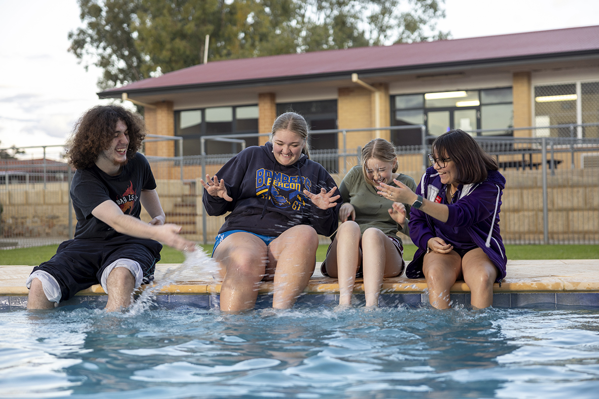 Merredin Residential College boarders sitting on the edge of the college pool
