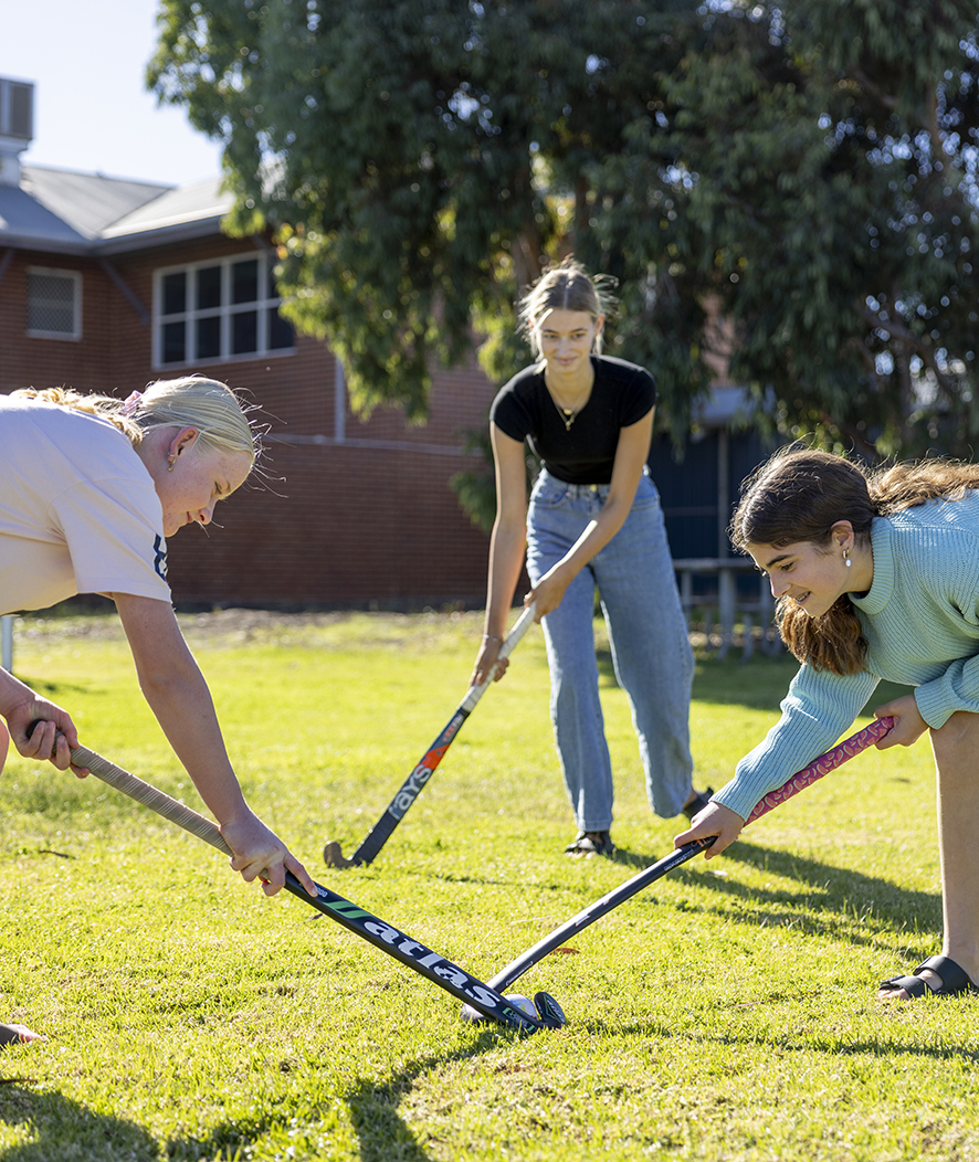 Narrogin Residential College boarders playing hockey on the college grounds.