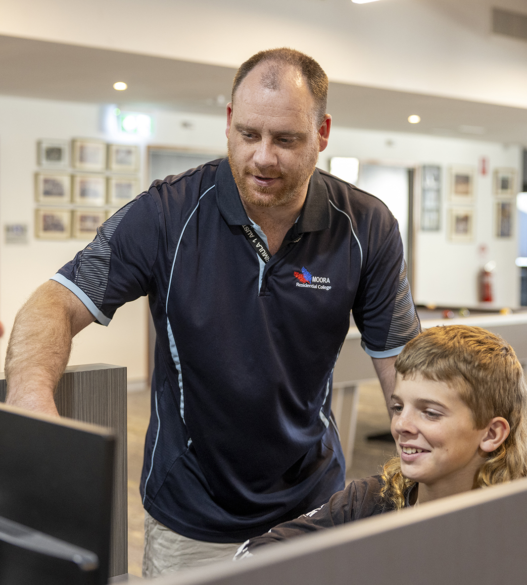 Moora Residential College supervisor helping a student at a computer.