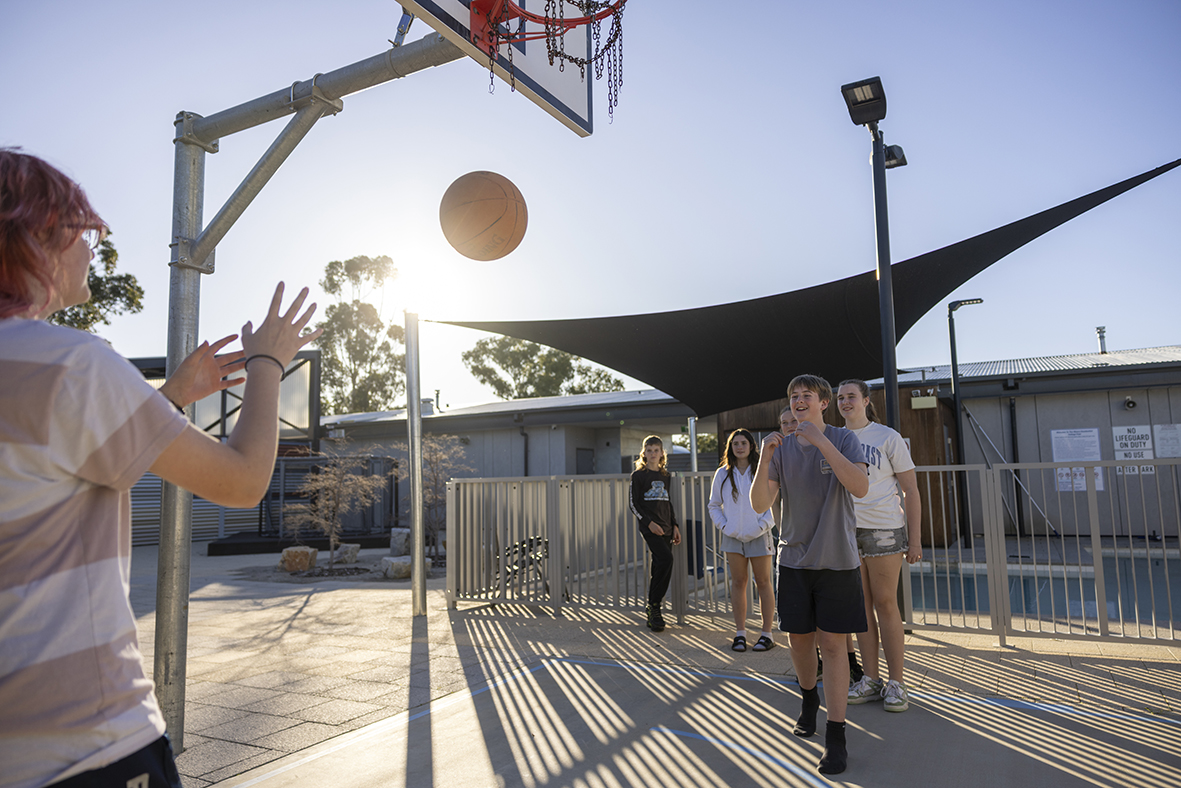 Moora Residential College boarders playing basketball on the college outdoor courts.