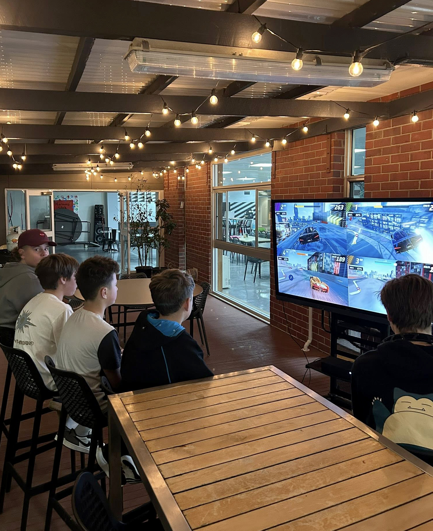 Boys playing xbox games on the deck at Albany Residential College.