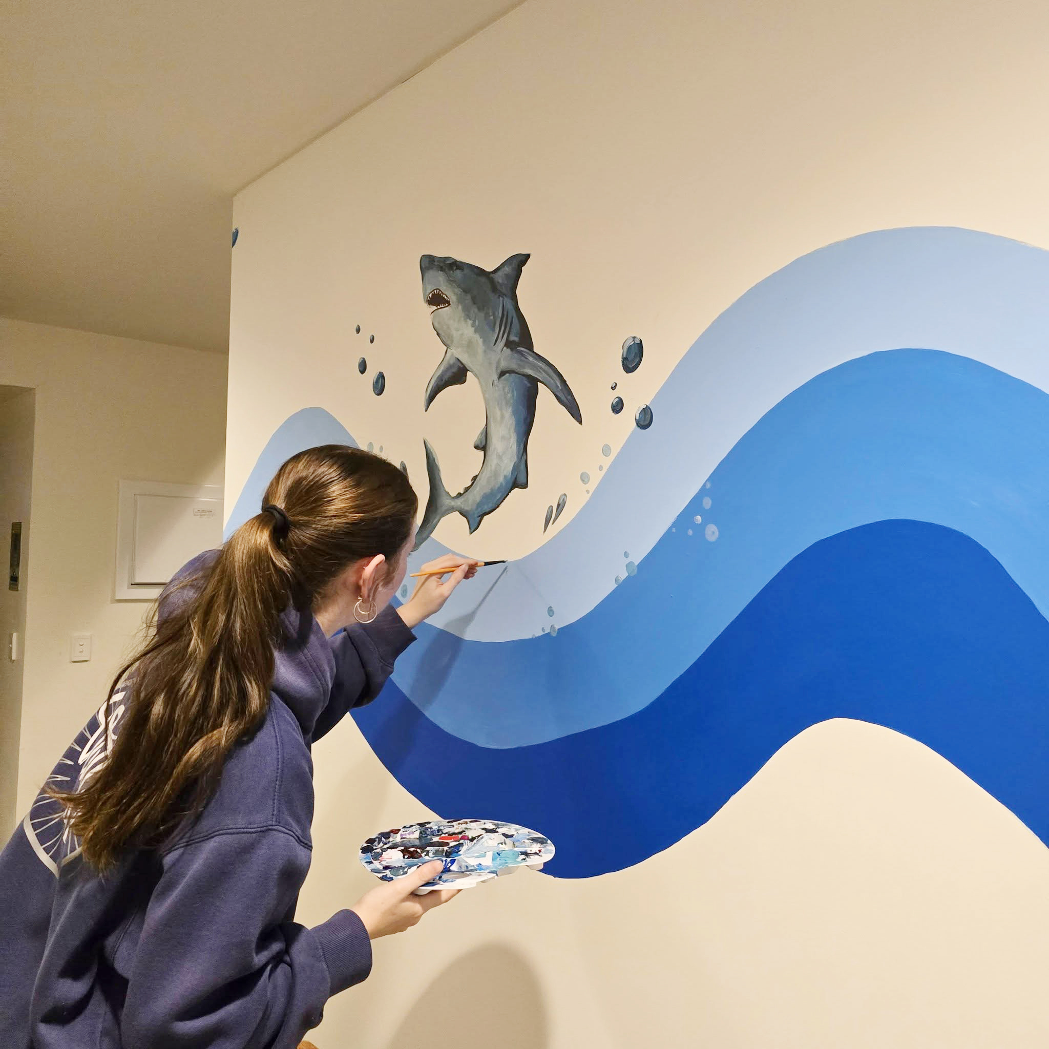 One of Esperance Residential College boarders painting a mural in the common area of the college.