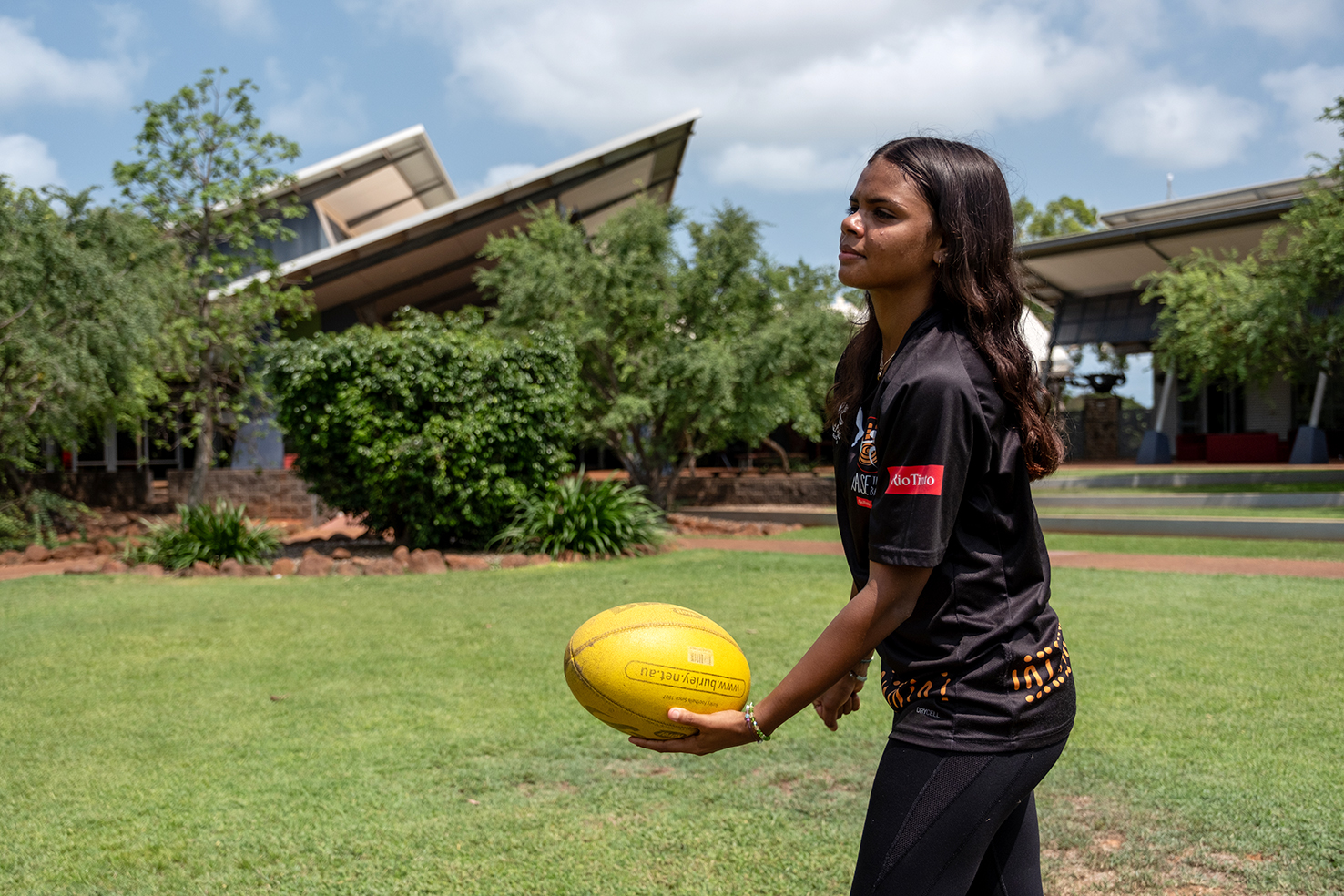 Boarder playing footy on the college oval at Broome Residential College.