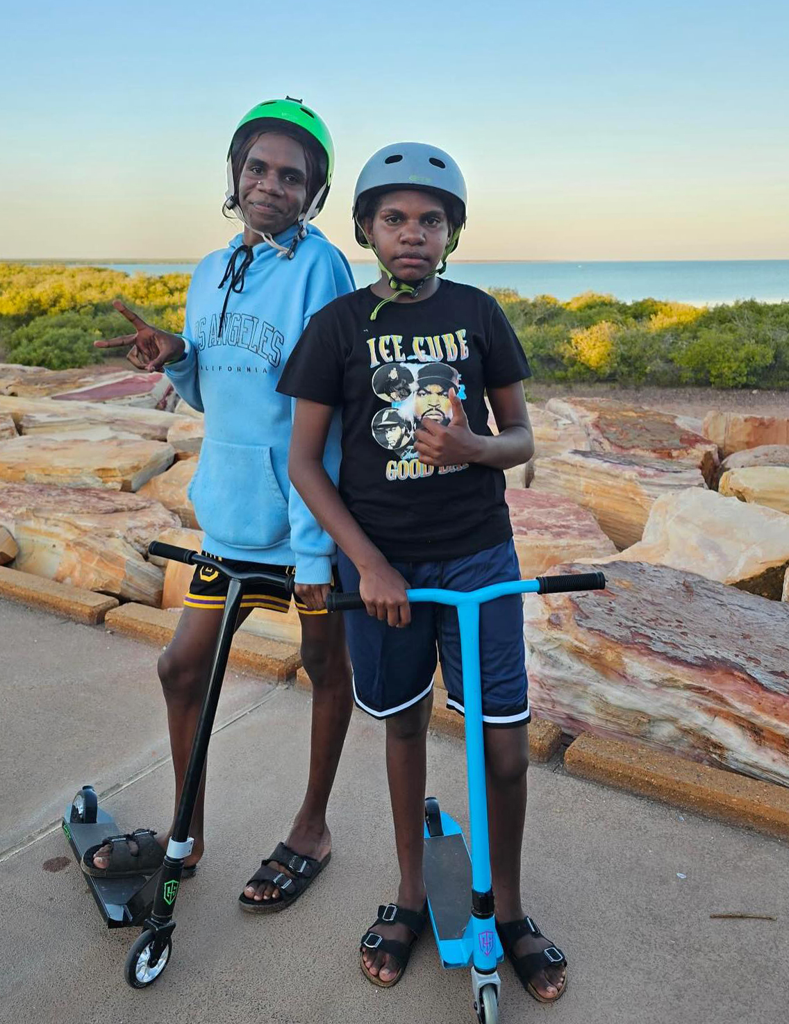 2 Broome Residential College boarders on scooters by the beach.