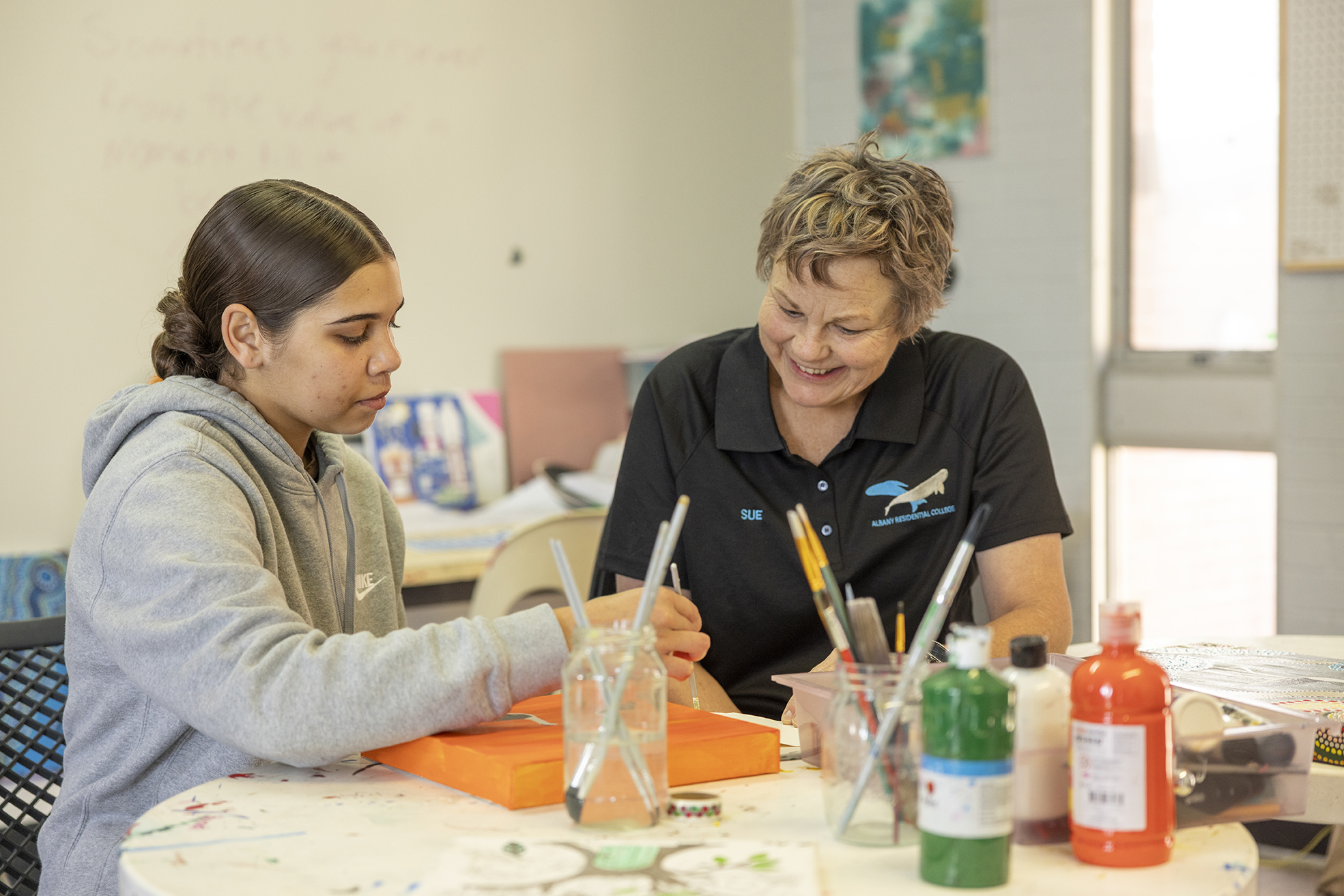 A boarding supervisor from Albany Residential College helping a student with their homework