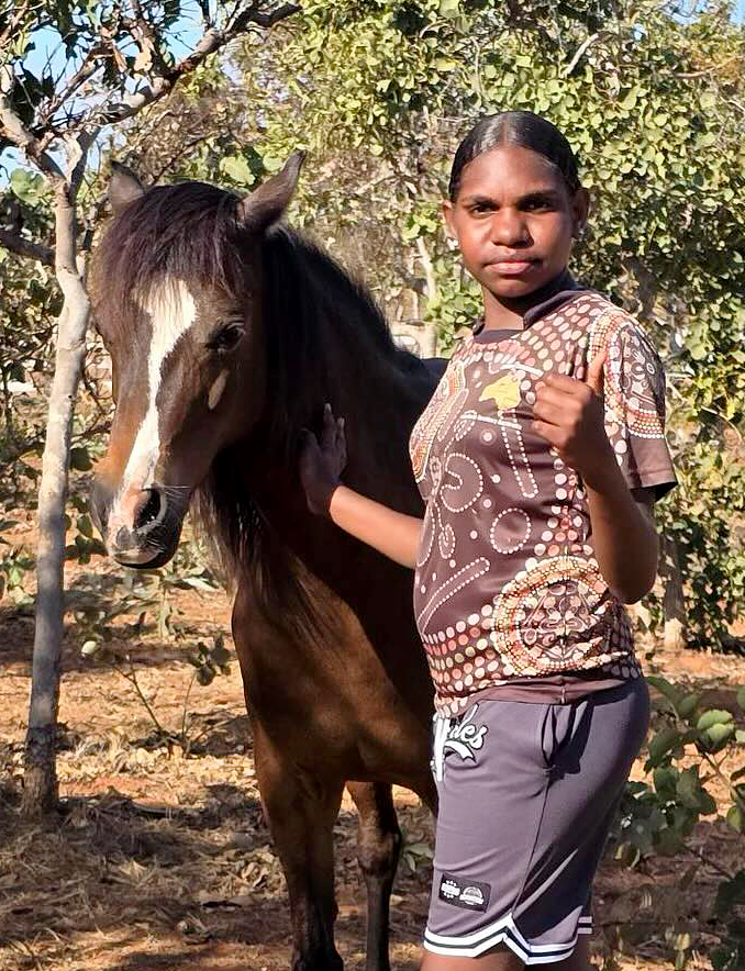 Broome Residential College boarder standing with a horse in the Yawardani Jan-ga Horse Therapy Program.