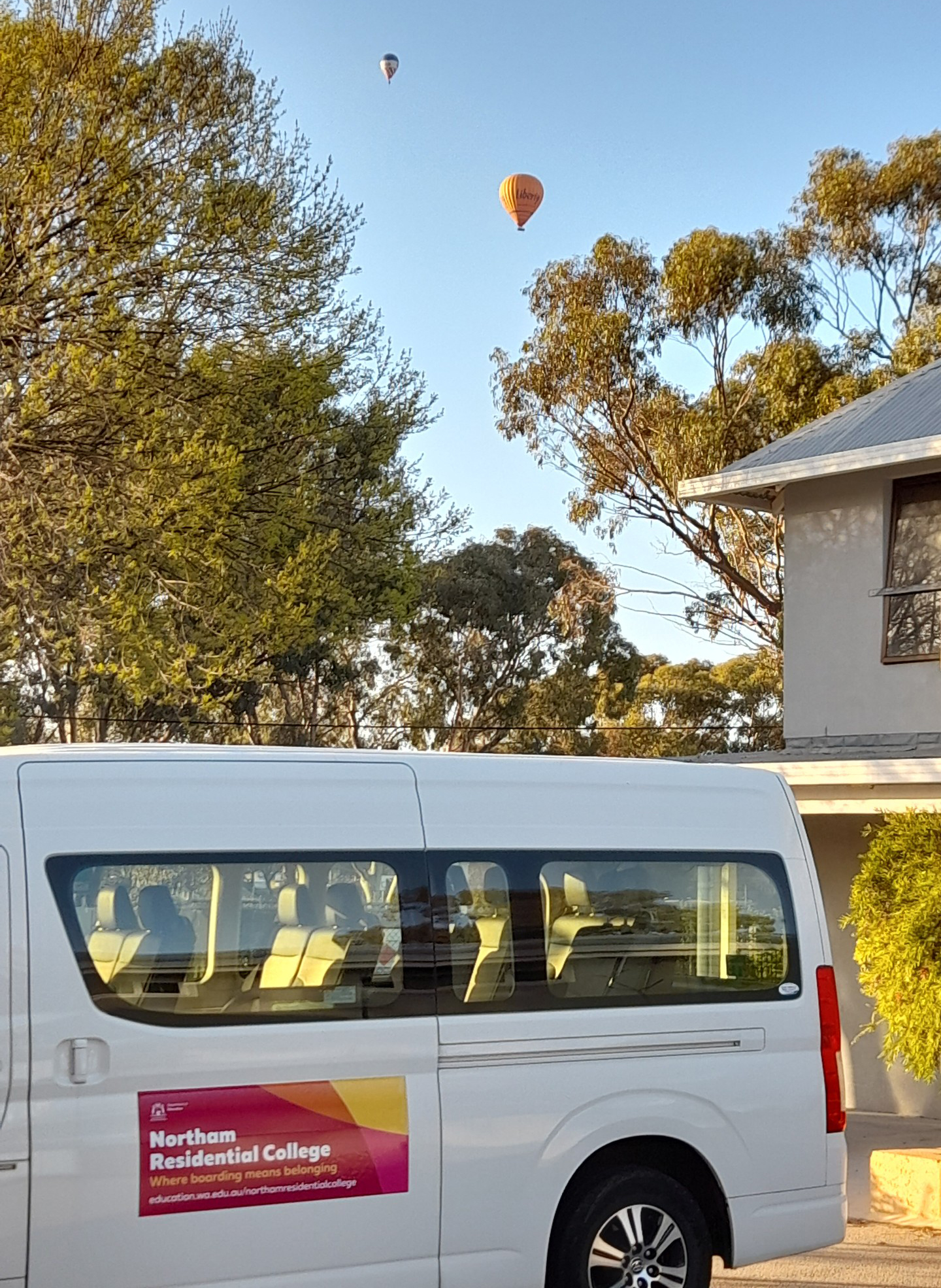 Northam Residential College bus with hot air ballons in the sky.