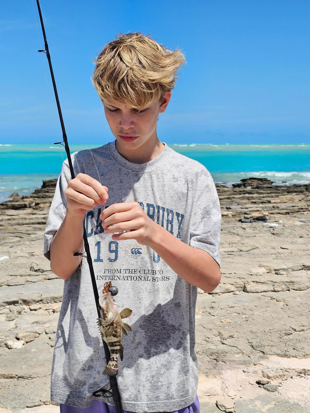 Broome Residential College boarder baiting a fishing line at Willie Creek.