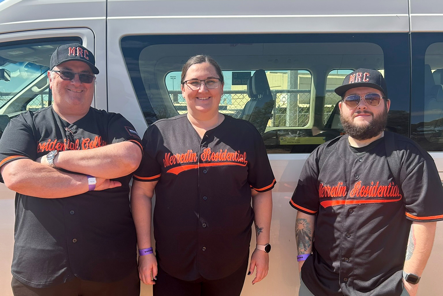 Three boarding supervisors from Merredin Residential College standing in front of the college bus.