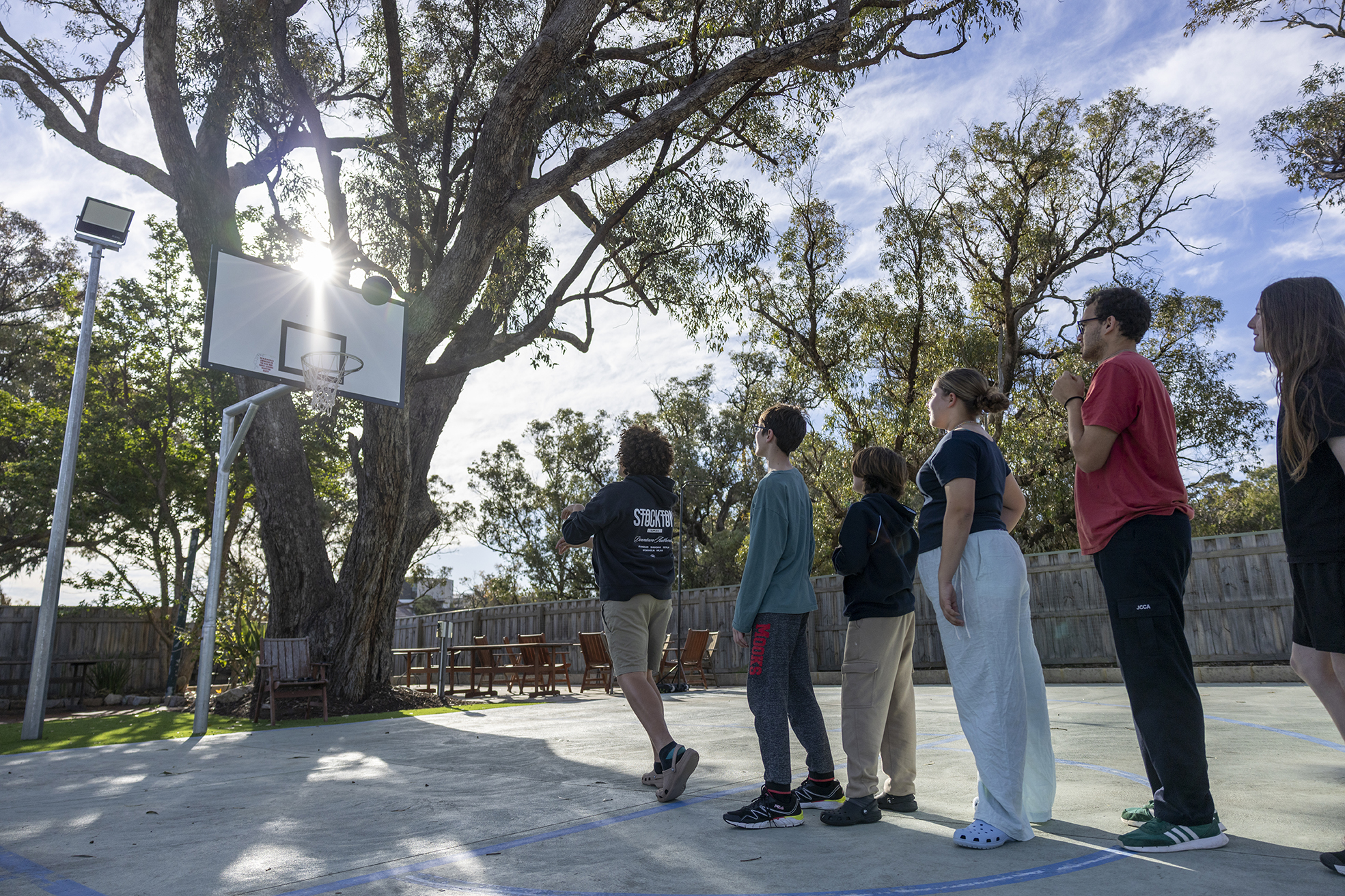 Boarders shooting hoops on the college court at City Beach Residential College