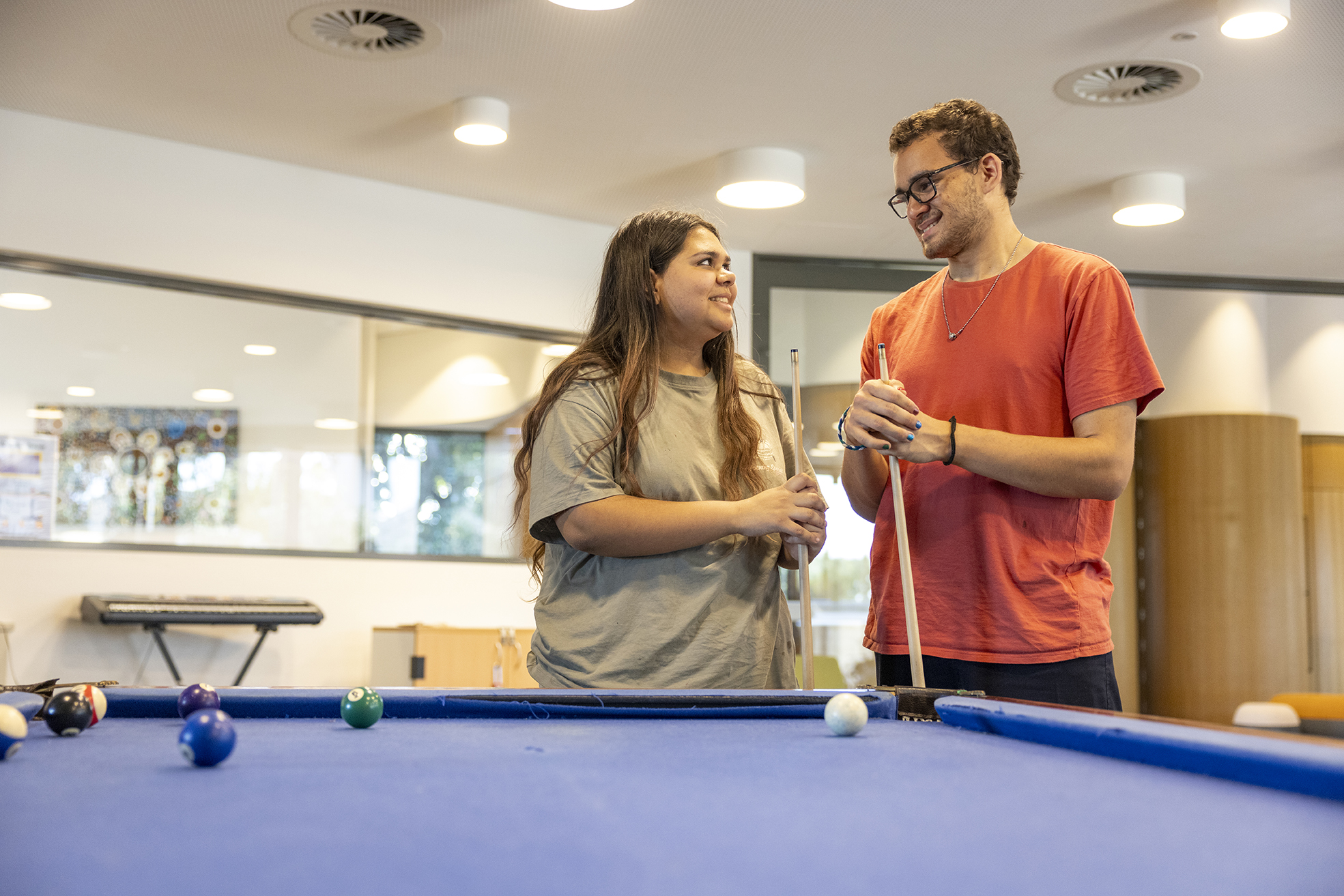 2 City Beach Residential College boarders standing at the college pool table.