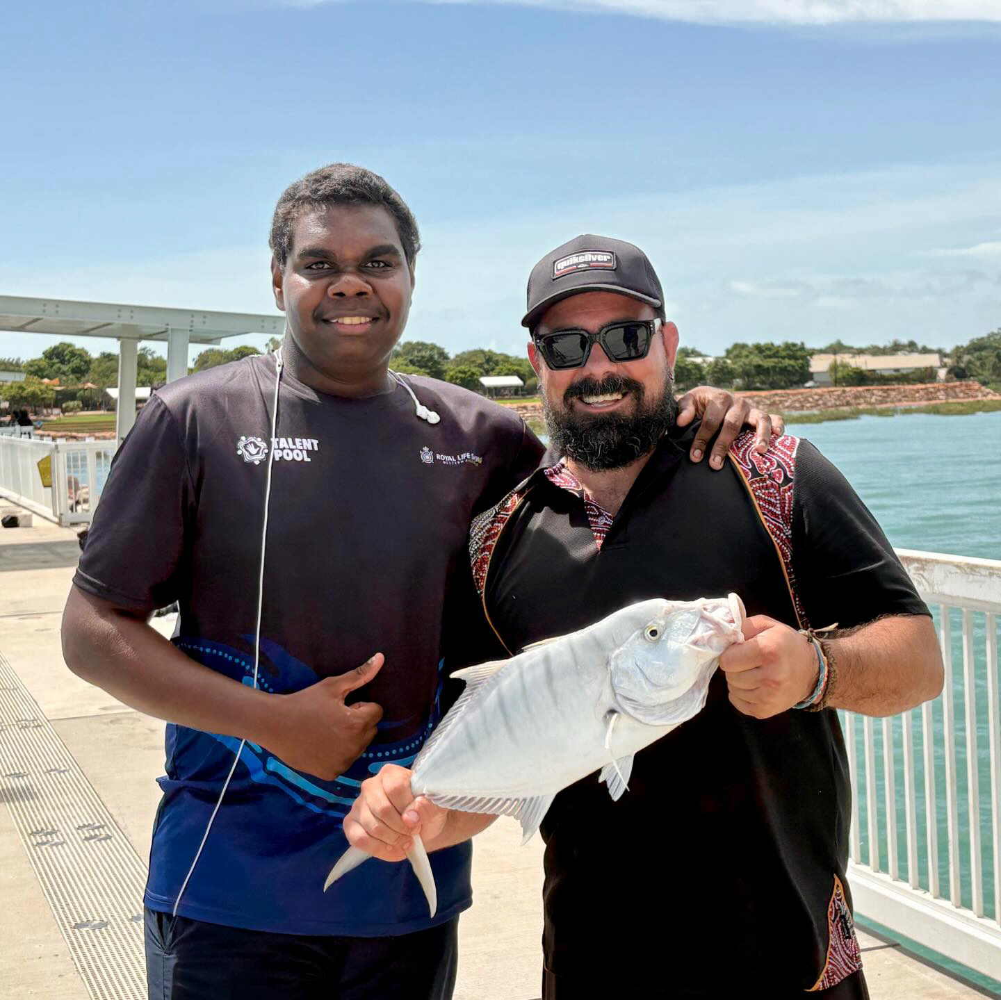 A Broome Residential College supervisor and boarder holding a fish, just caught while fishing off the jetty.