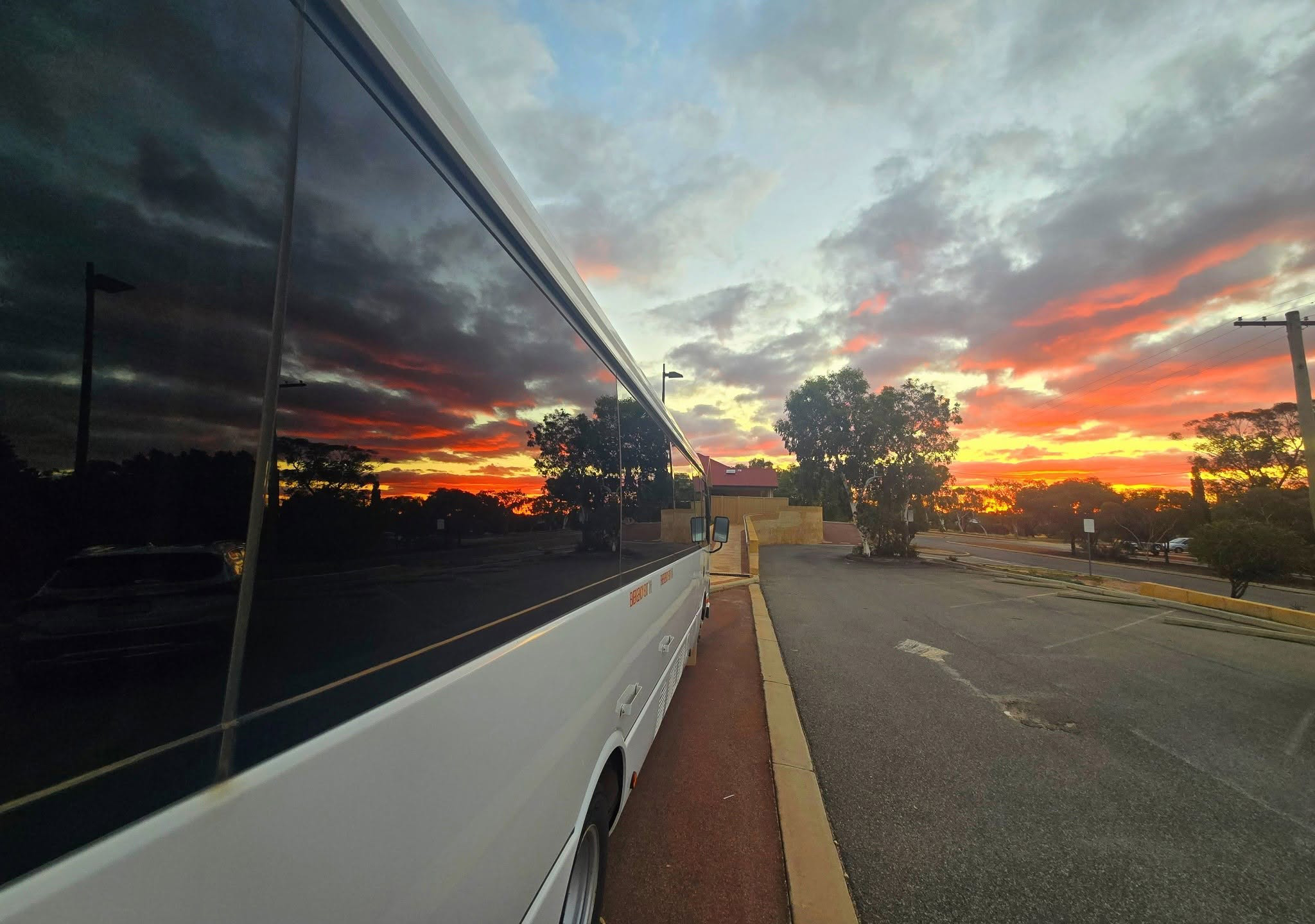 the big bus at Merredin Residential College against a bright sunrise reflecting in the windows.