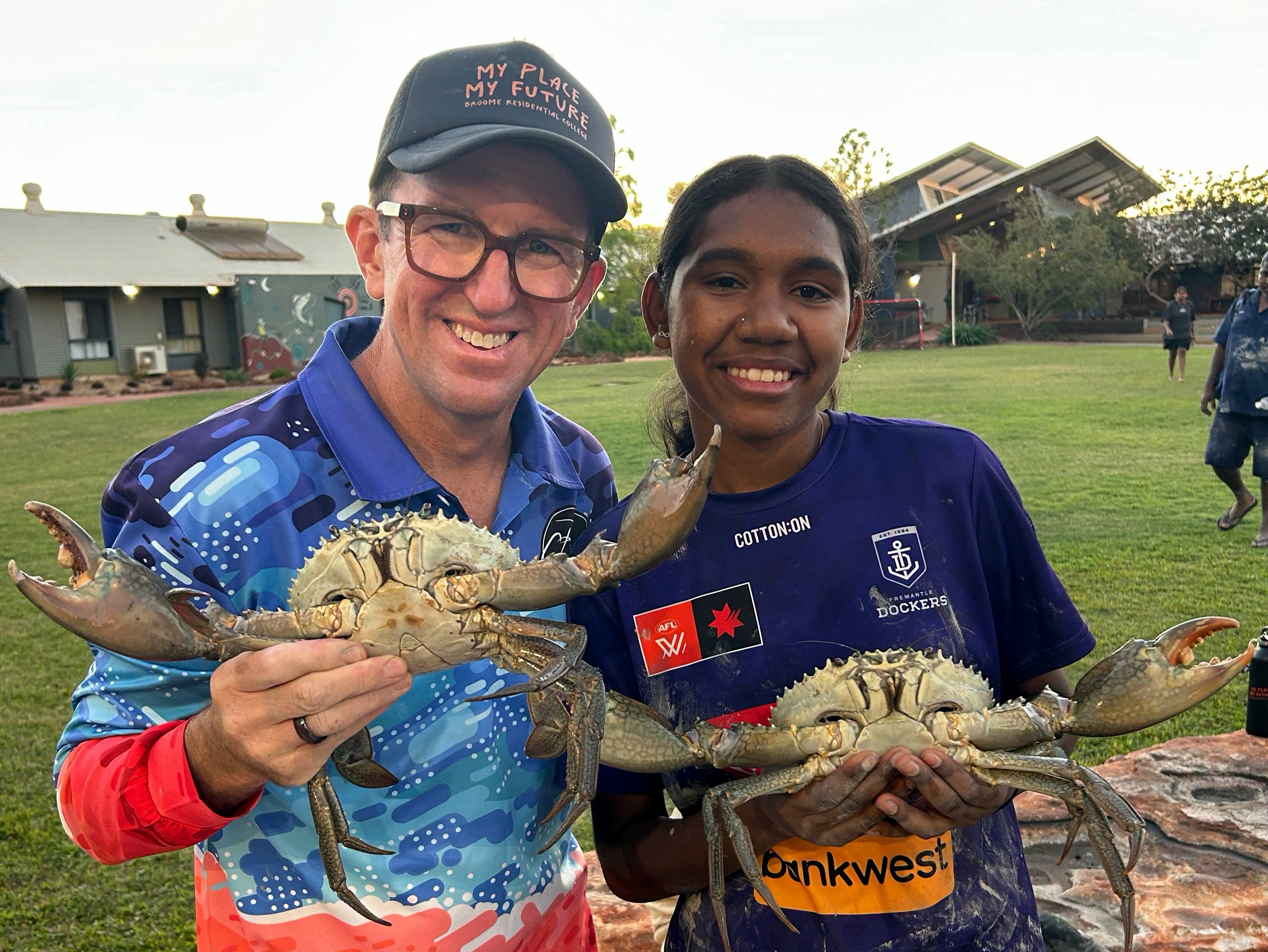 Broome Residential College boarding supervisor and boarder holding large mudcrabs, caught on an excursion to the mud flats.