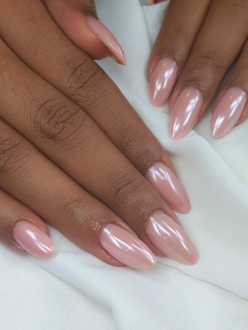 Manucure rose pâle brillante sur ongles en amande