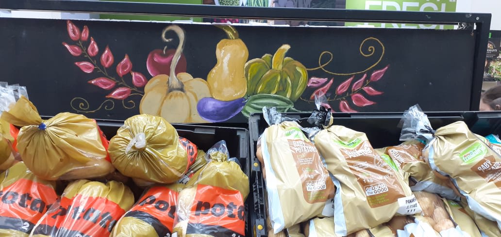 Produce section with vibrant vegetable artwork