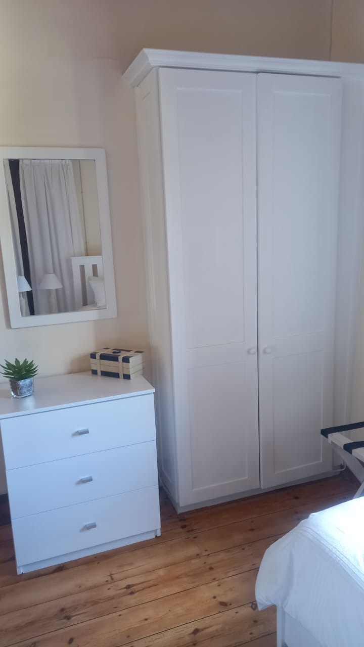 Wardrobe and tall chest of drawers in bedroom setting