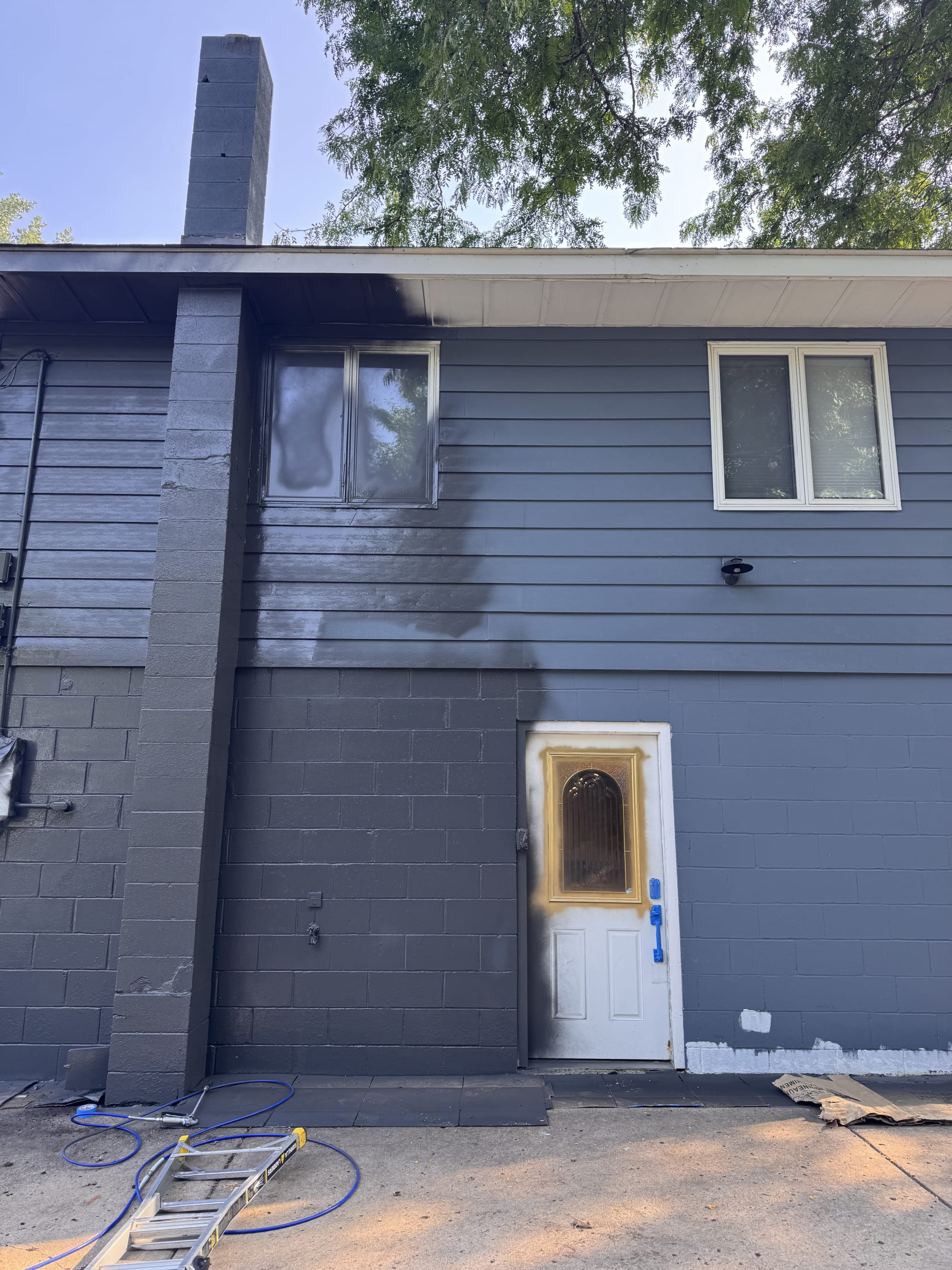 Exterior painting in progress at CJ and Katy Norman’s home on Black Lake in Mound