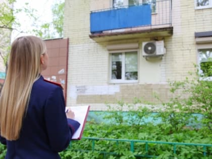 Следователь Следственного комитета работает на месте происшествия, где из окна дома выпал ребенок