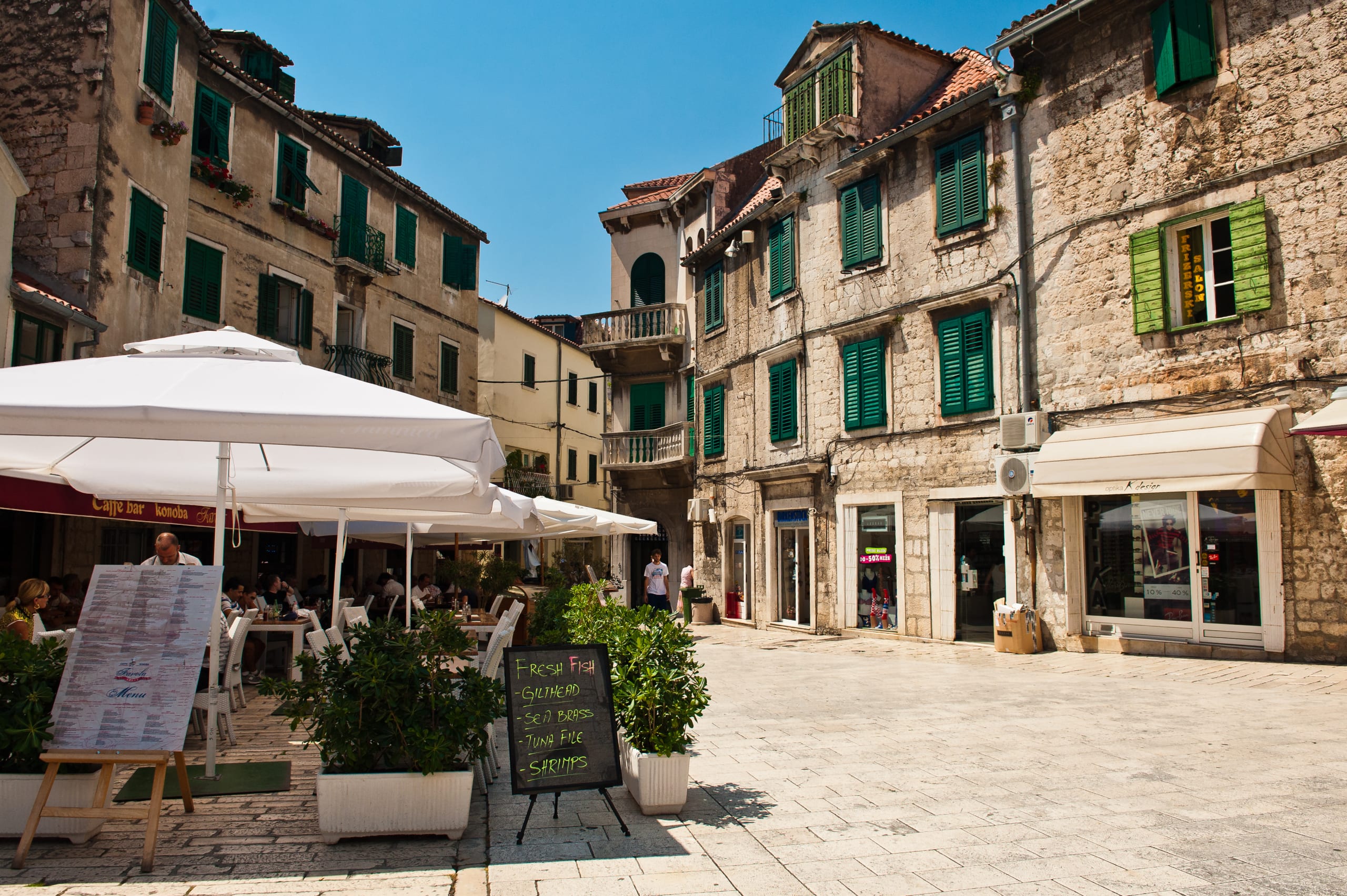 Small restaurant in Split, Croatia. Restaurant tables under white umbrellas in the historic centre of Split,Croatia.