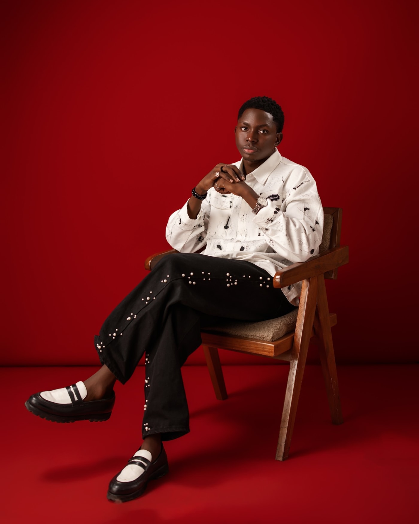 Oluwafemi Oduneye seated in a wooden chair