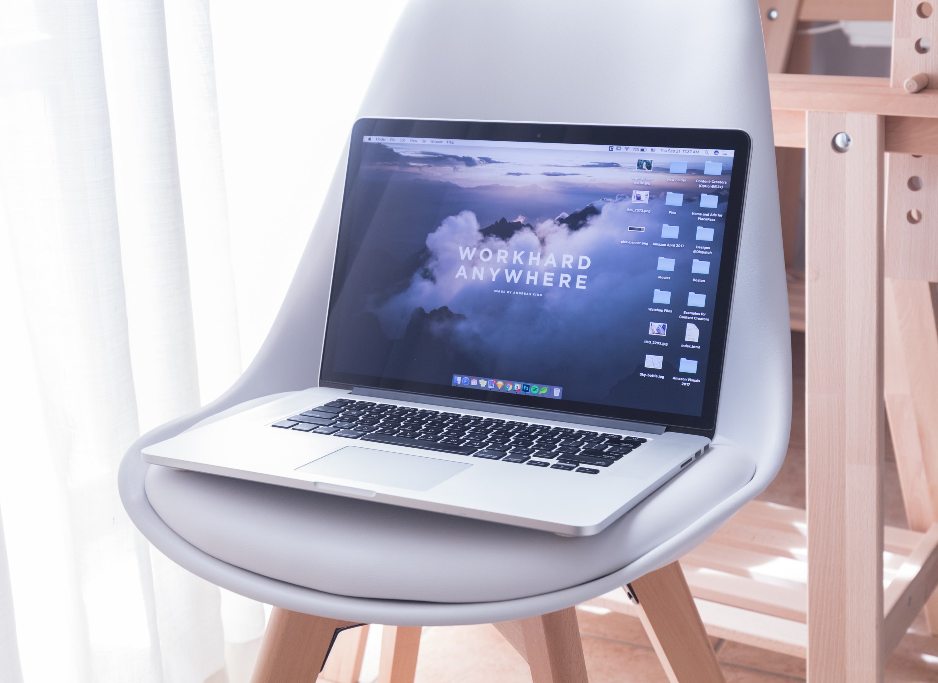 A laptop in a chair with caption Work Hard Anywhere