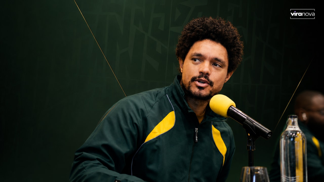Editorial visual representing Trevor Noah’s South Africa’s Festival of Comedy as a national-team-style comedy event, featuring a stadium comedy stage, microphone spotlights, squad announcement cues, press-conference energy and premium Viranova purple-and-gold glass styling.