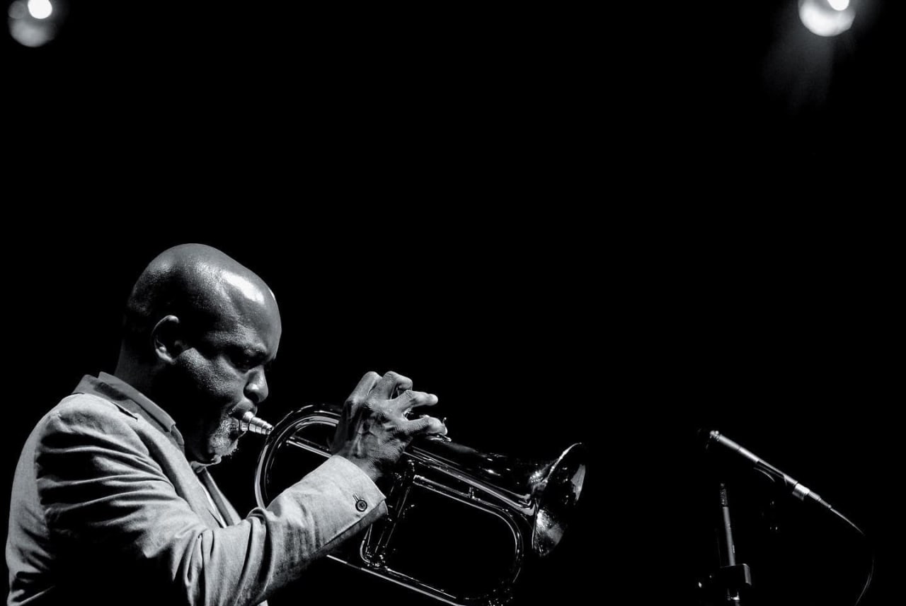 Editorial visual representing Sydney Mavundla’s Jazz at Jozi Gold performance in Braamfontein, featuring warm trumpet-stage light, brewery atmosphere, 81 De Korte Street cultural memory, Orbit-inspired jazz textures and premium Viranova purple-and-gold glass styling.