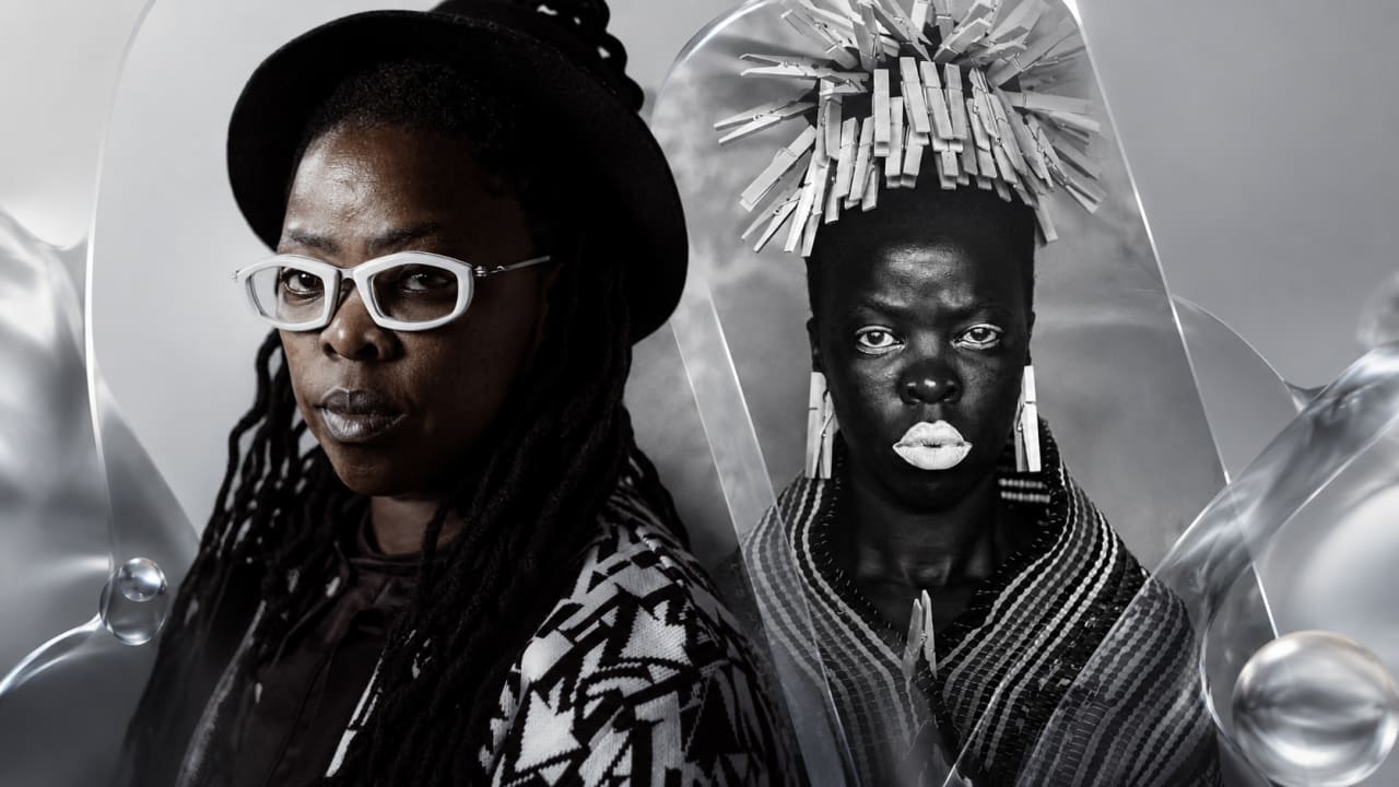 Editorial visual representing Zanele Muholi’s Kanye Nawe exhibition at Southern Guild Cape Town, featuring a powerful gallery installation of Black-and-white portraiture, self-portrait imagery, bronze sculpture forms, V&A Waterfront Silo District atmosphere, deep purple shadows, warm gallery light, gold highlights and premium Viranova glass styling.