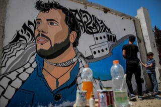El artista Omar Al-Qarshall pinta en un muro de Gaza el retrato de Thiago Ávila (secuestrado y liberado, de la Flotilla)