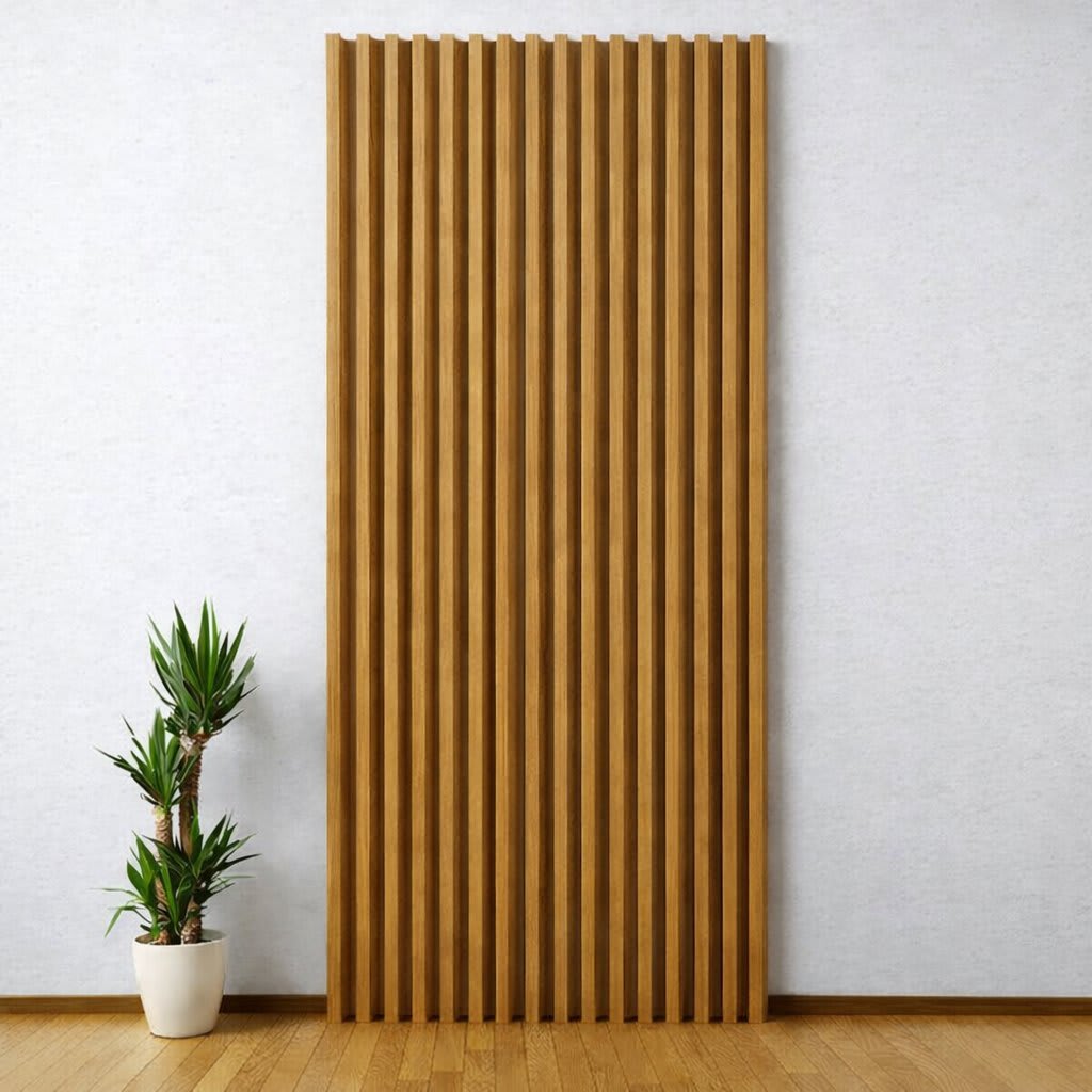 A tall, vertical WPC wall panel with natural walnut textured slats stands out against a light-colored wall in a minimalist, modern interior, paired with a small potted plant on a warm wooden floor, creating a serene and clean design.