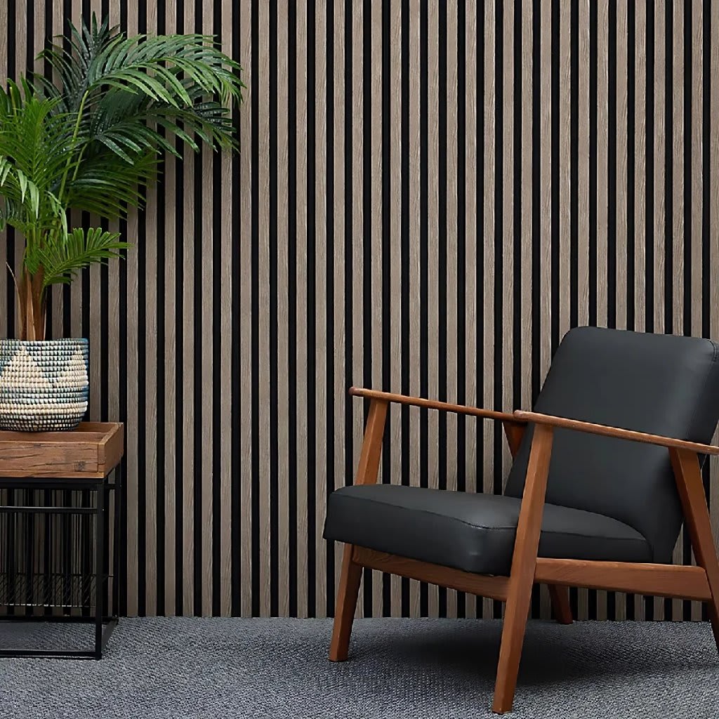 A minimalist and modern living room interior featuring walnut veneer acoustic panels, textured slatted wall panels, and a woven plant pot with green foliage, creating a warm, elegant, and contemporary atmosphere.