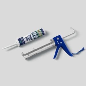 A blue silicone gun next to a tube of sealant on a neutral background, ideal for installing wall panels, DIY home repairs, construction sealing, and applying adhesives in tutorials, catalogs, and tool-focused designs.