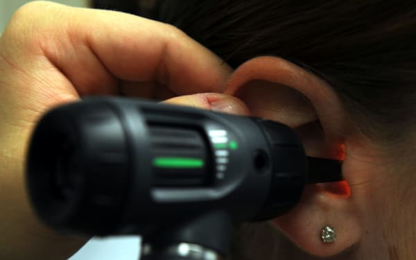 Clinician examining a patient's ear