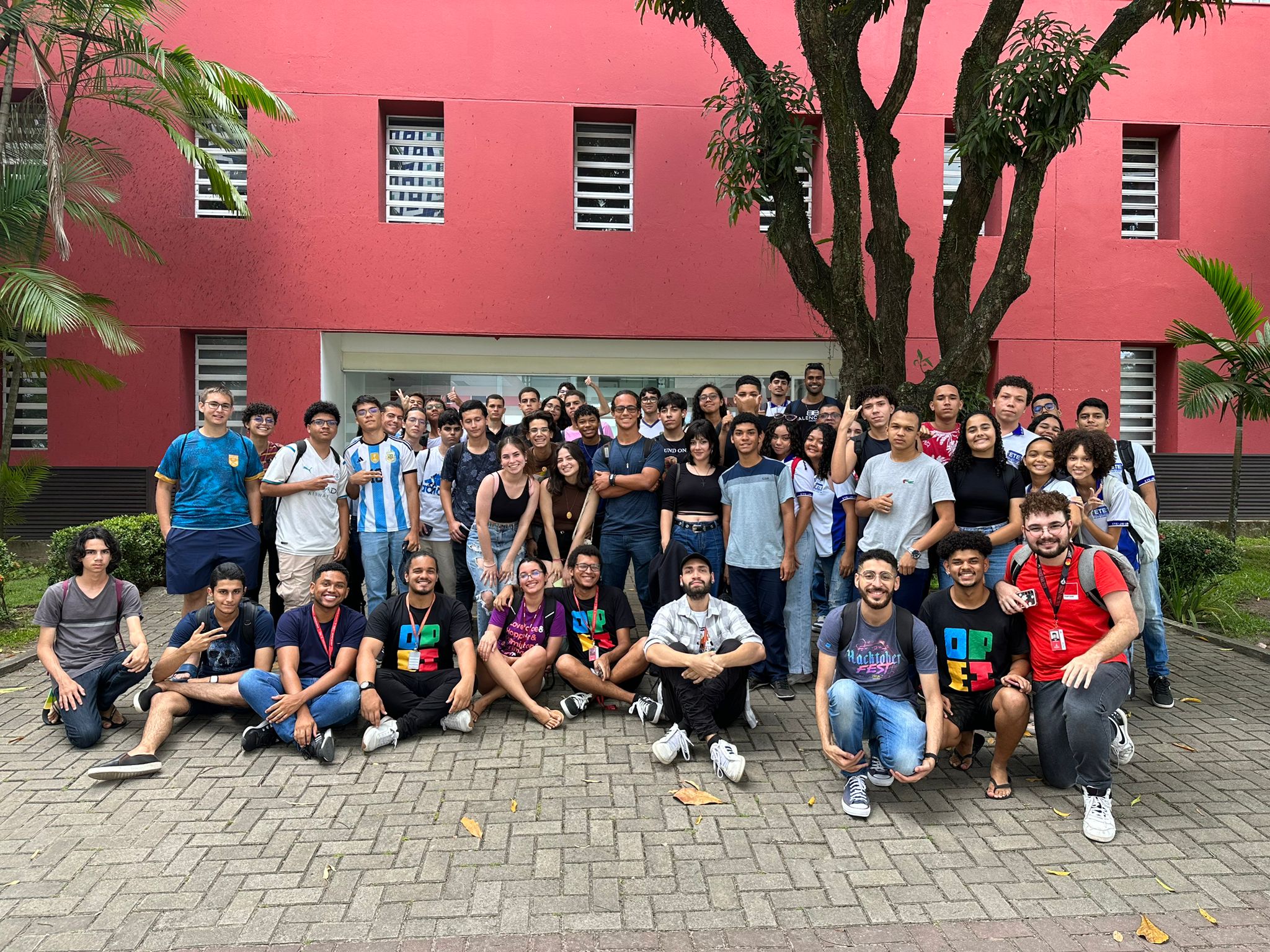 Integrantes do PET Informática junto à estudantes de ensino médio que participaram do conecta pet. Ao fundo, o centro de informática da universidade federal de pernambuco.