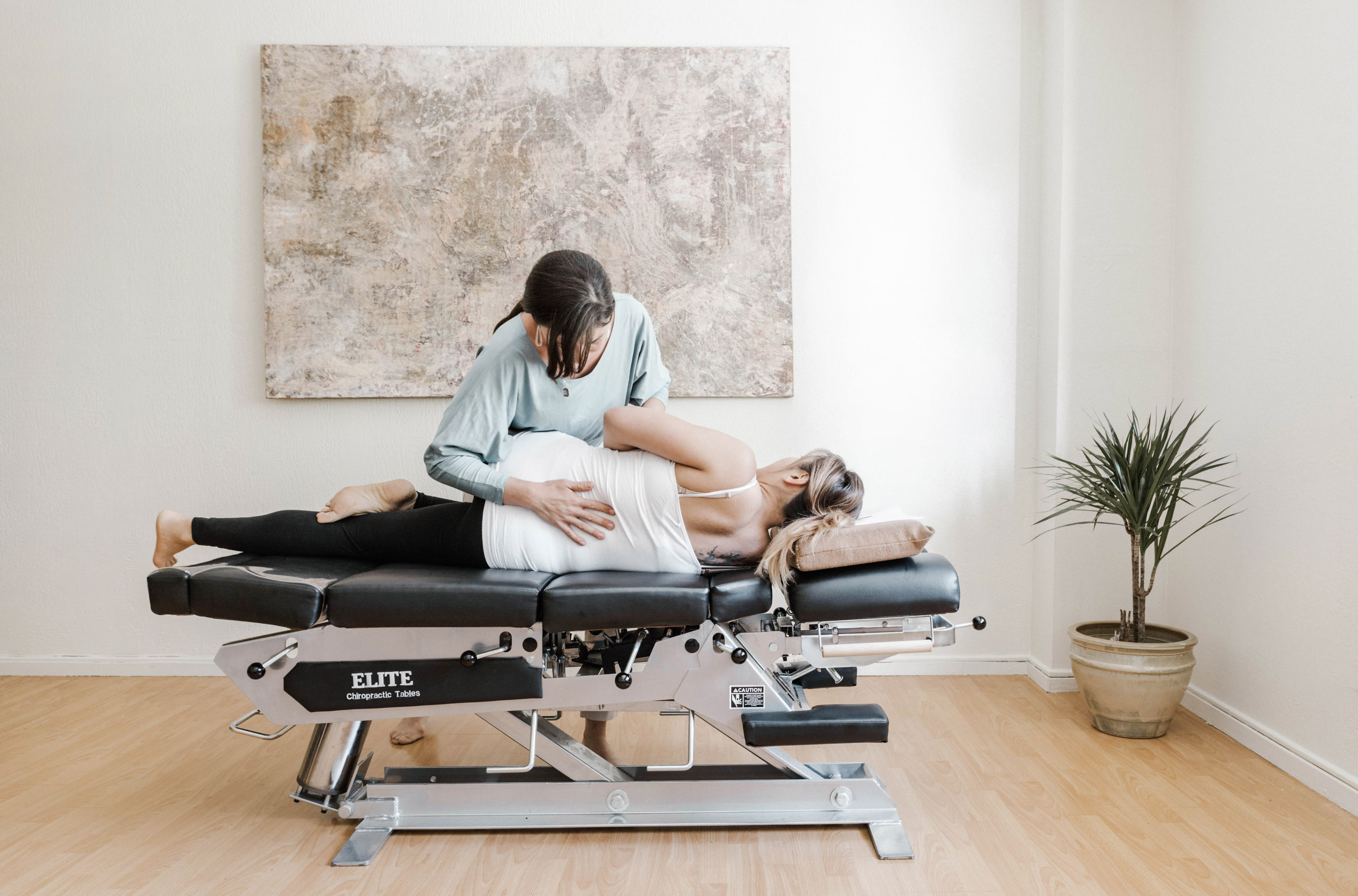 Chiropractor performing spinal adjustment on patient on Elite table for back pain relief at The Shift Chiropractic in Oakland
